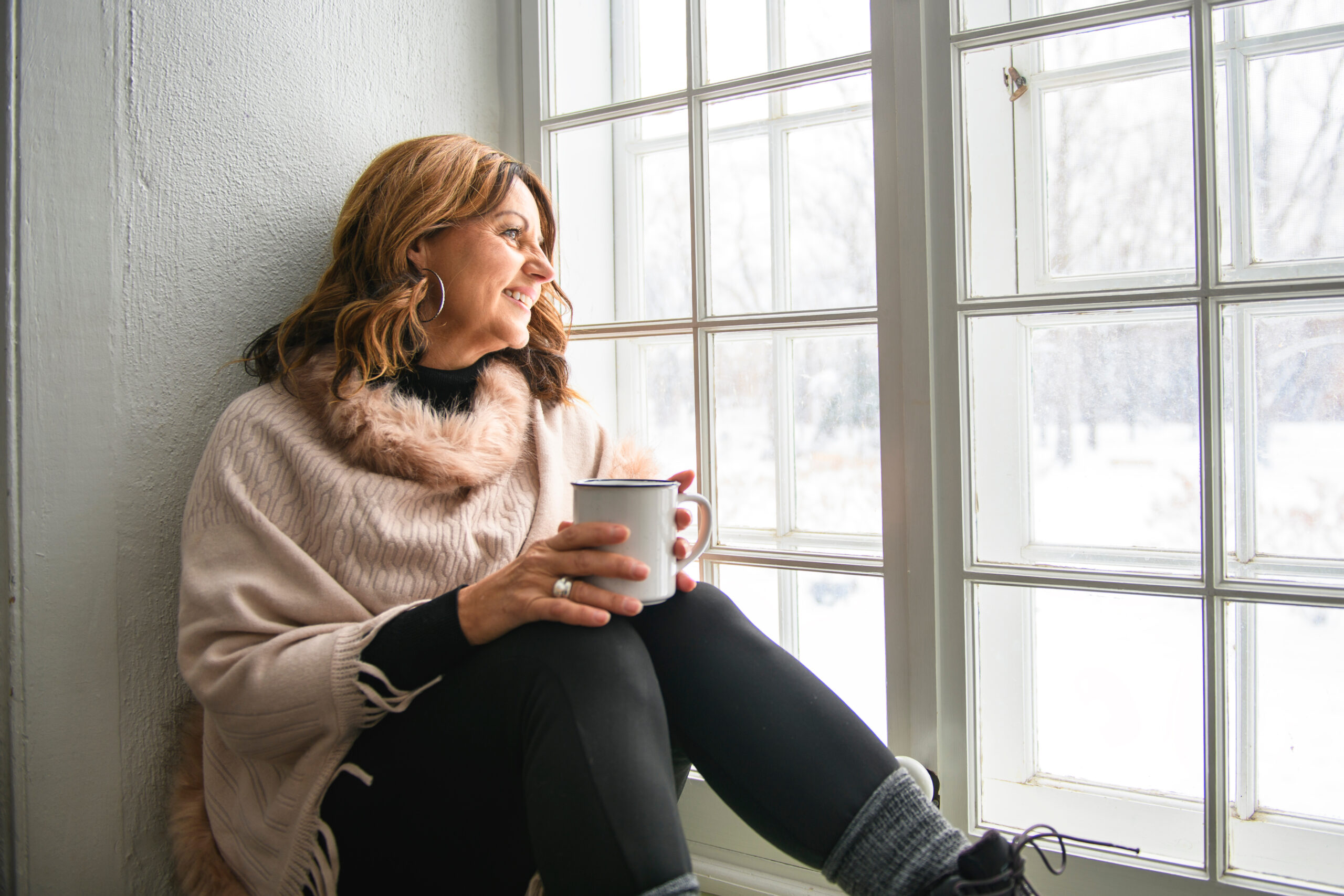 A Portrait of mature woman inside on the window side